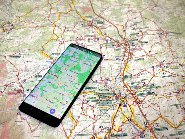 Ausgebreitete Fahrradkarte der RadReiseRegion Uelzen auf der ein eingeschaltetes Smartphone mit der laufenden Navigationssoftware "OsmAnd" liegt.